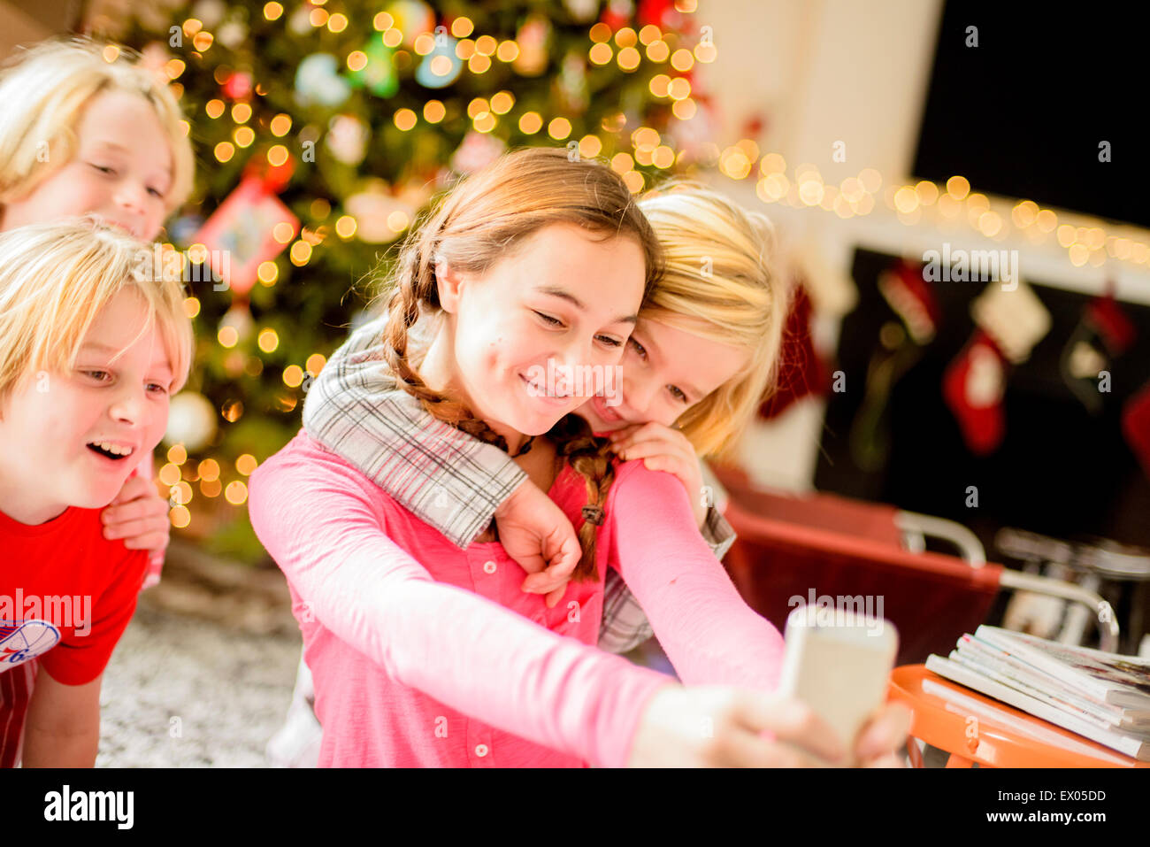 Adolescente et frères en tenant sur smartphone selfies à Noël Banque D'Images