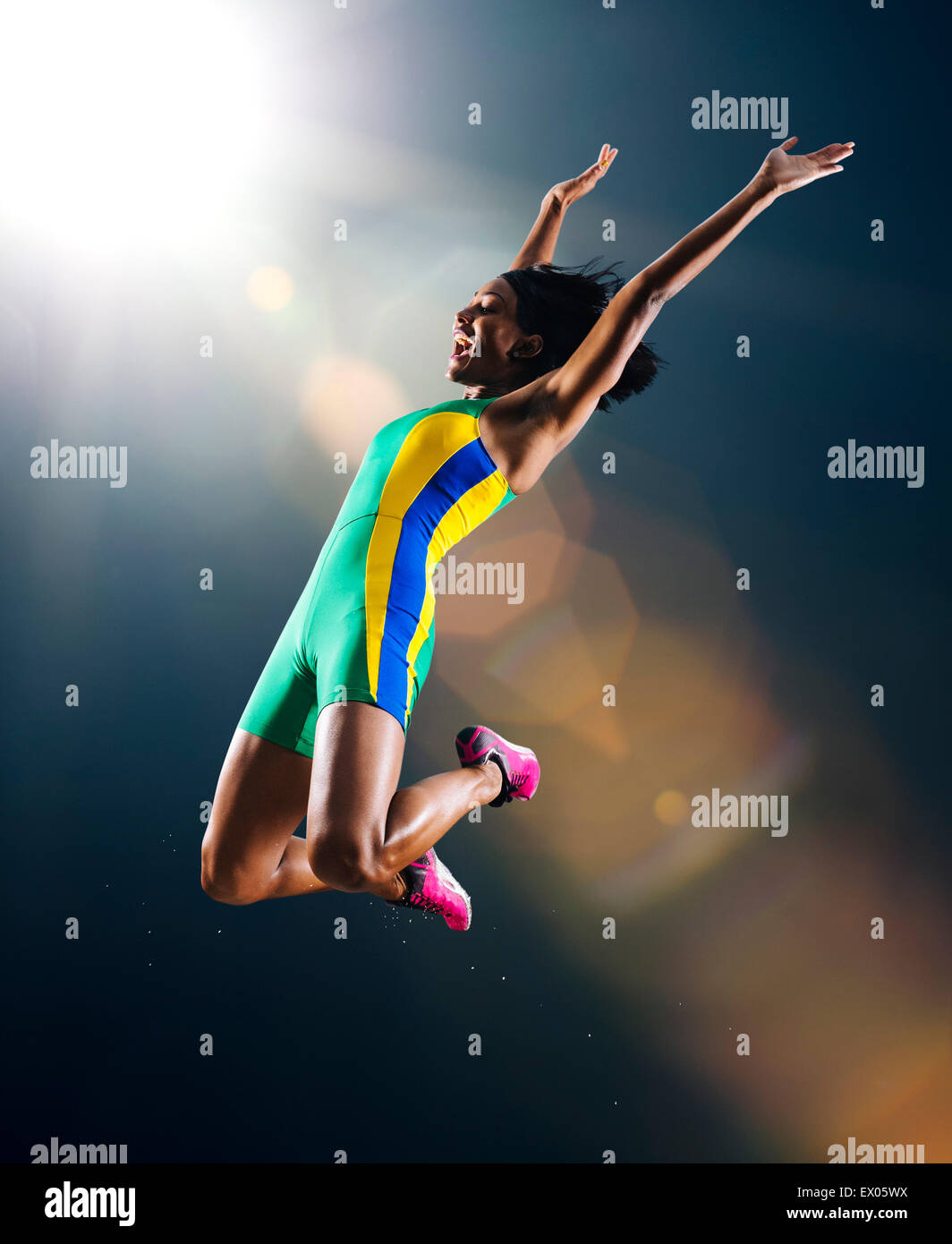 Jeunes femmes athlètes jumping mid air dans la célébration dans le stade Banque D'Images