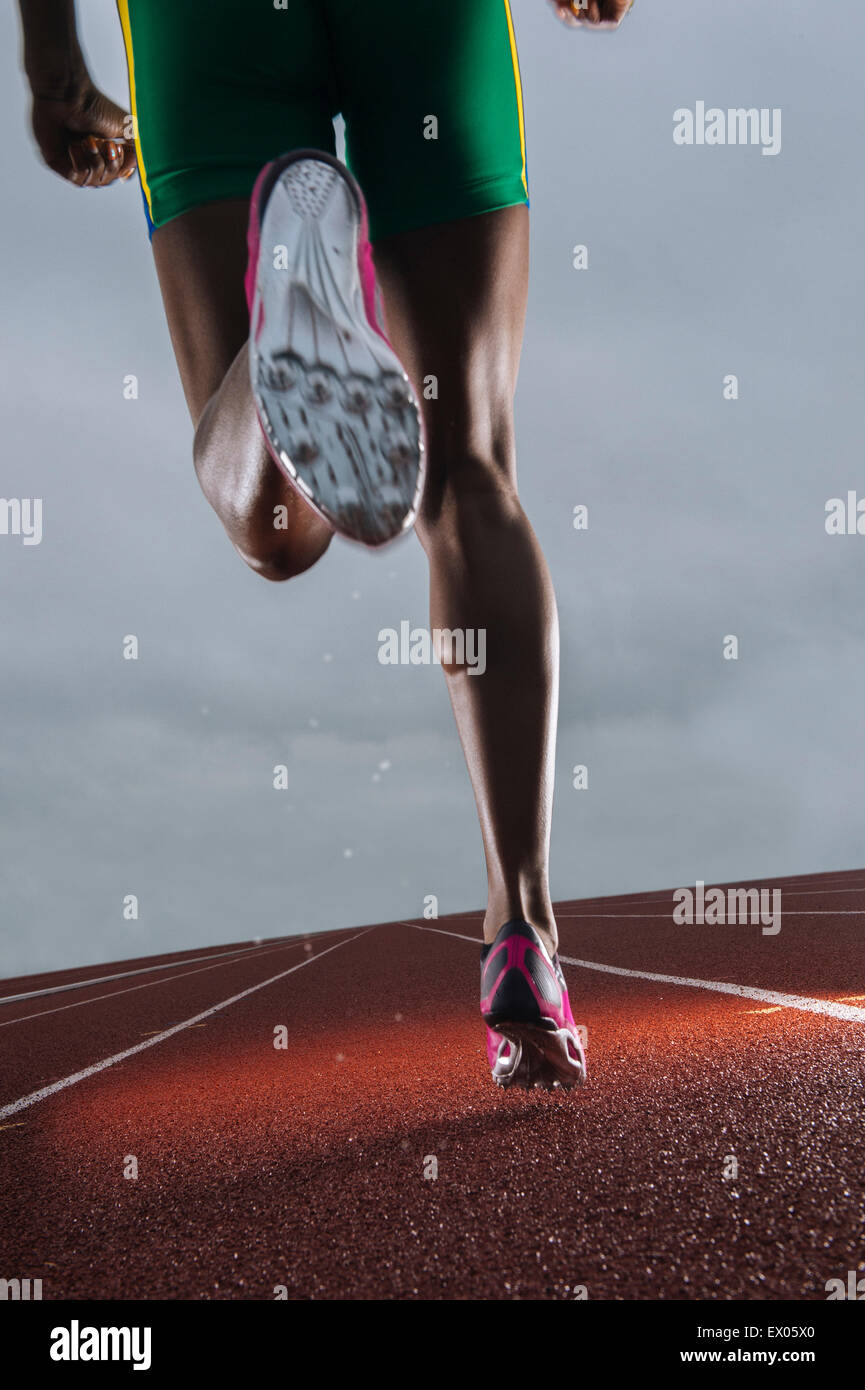 Vue arrière de jeunes athlètes femmes jambes s'exécutant sur la piste de course Banque D'Images