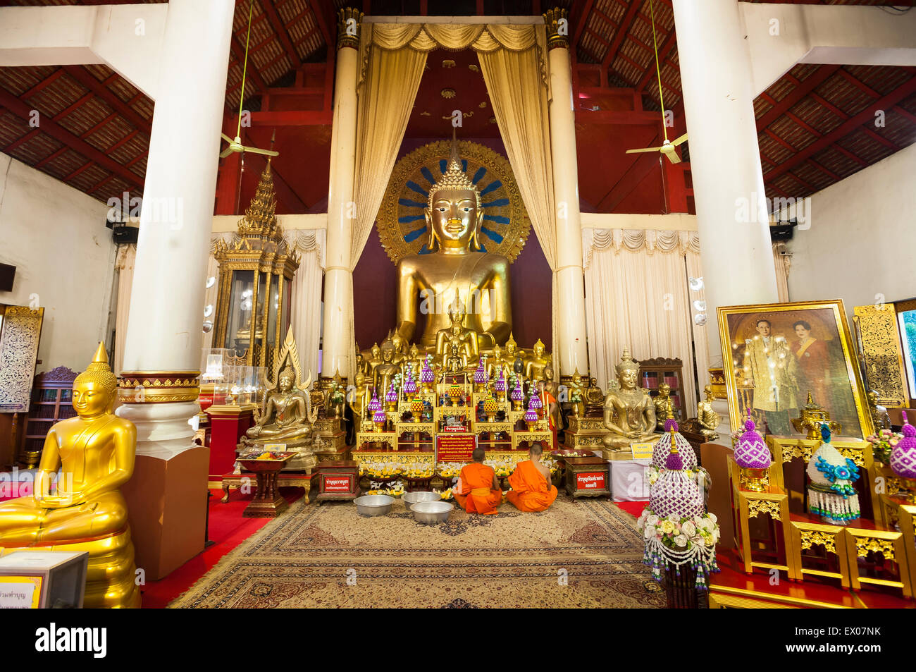 Jeunes moines en prière devant l'autel principal de l'Wiharn Luang à Wat Phra Singh, Chiang Mai Banque D'Images