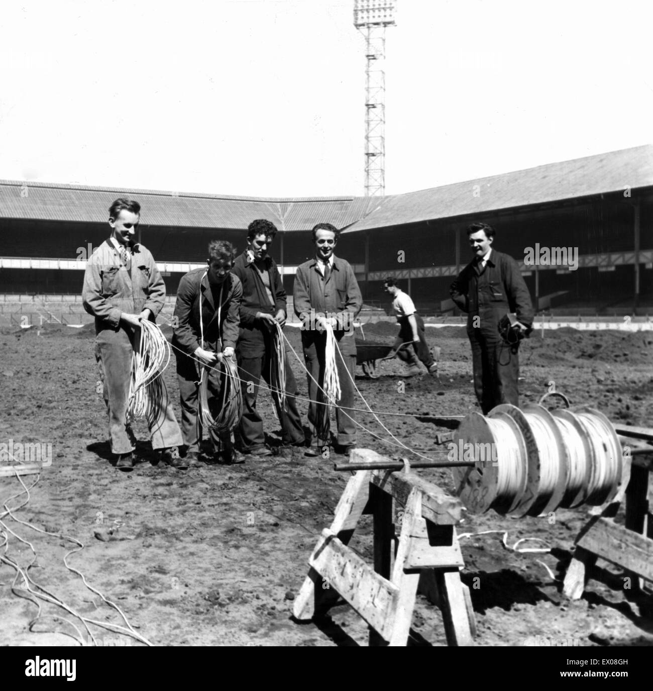 De Goodison Park, home à Everton FC, le stade de football est situé dans la région de Walton, Liverpool, Angleterre. 8 mai 1958. Une équipe d'électriciens MANWEB payer le câble spécial à Goodison, qui aidera à réduire le gel, congelé et le besoin d'emplacements annuler mat Banque D'Images