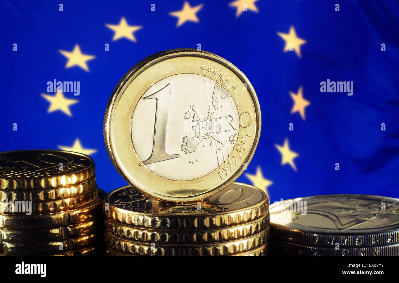 Une pièce d'un euro devant un drapeau européen Banque D'Images