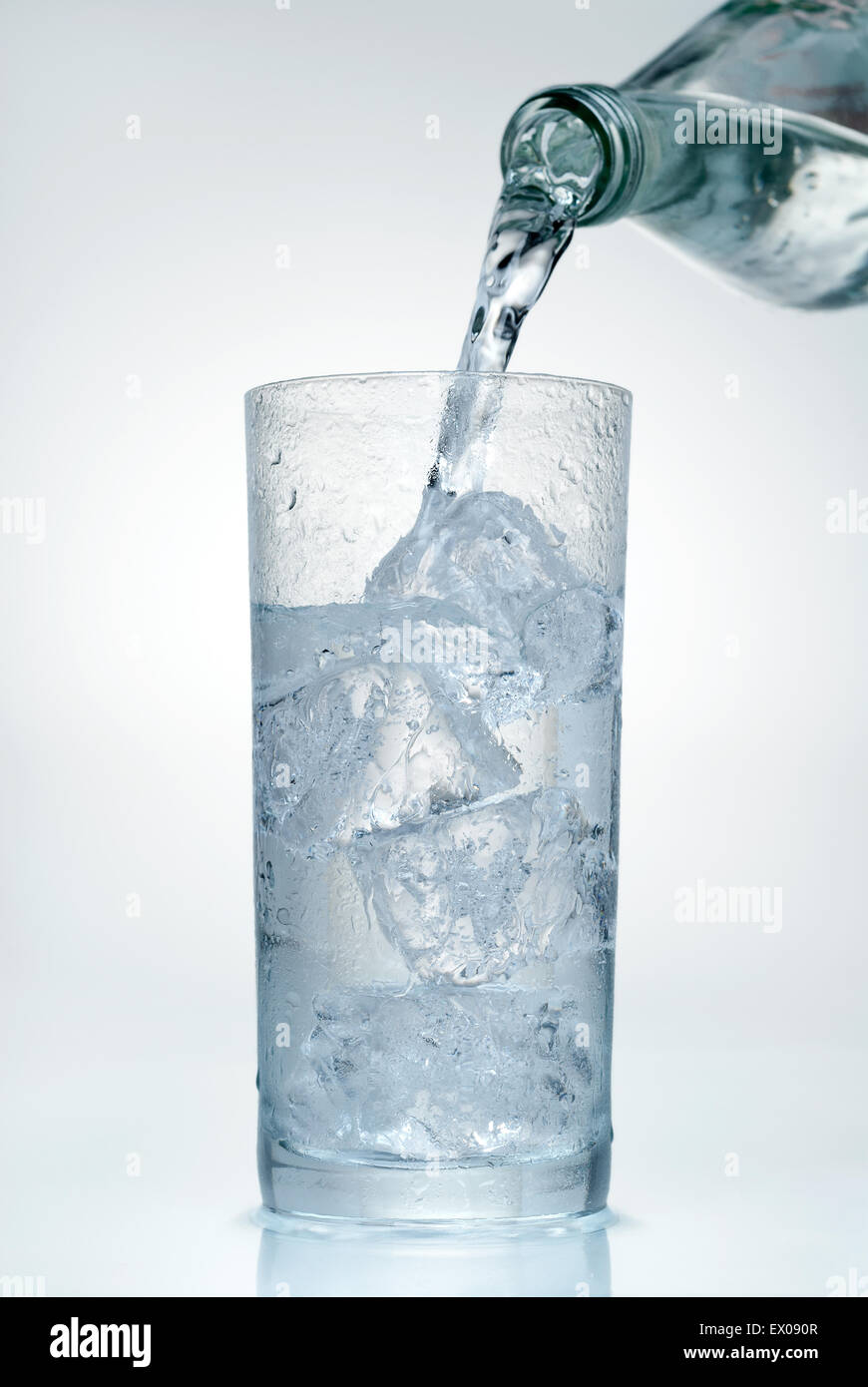 L'eau minérale est versé dans un verre. Banque D'Images