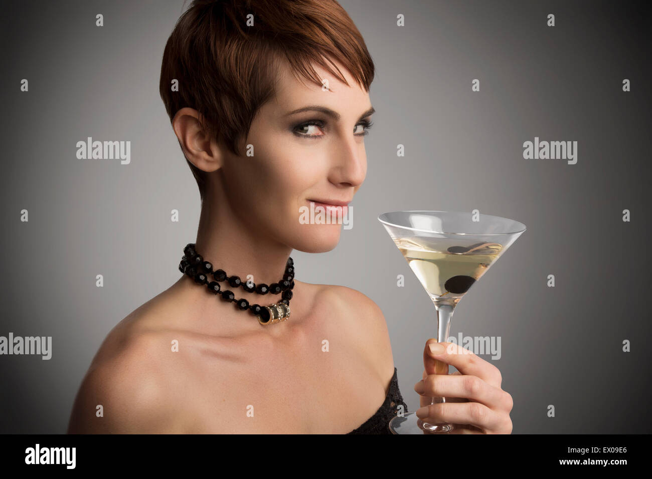 Studio portrait of woman looking sideways holding cocktail Banque D'Images