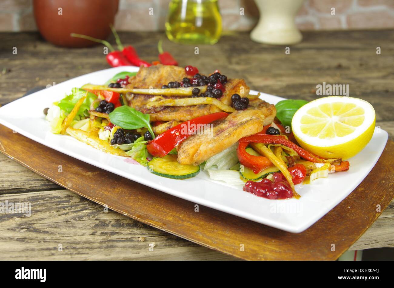 Le poisson frit avec des légumes sur plaque blanche Banque D'Images