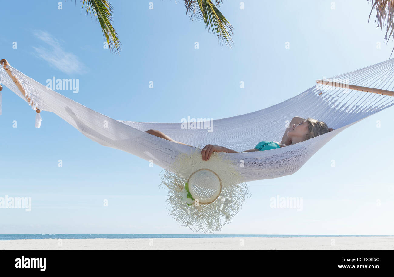 Jeune femme couchée sur hamac sur Miami Beach, Floride, USA Banque D'Images