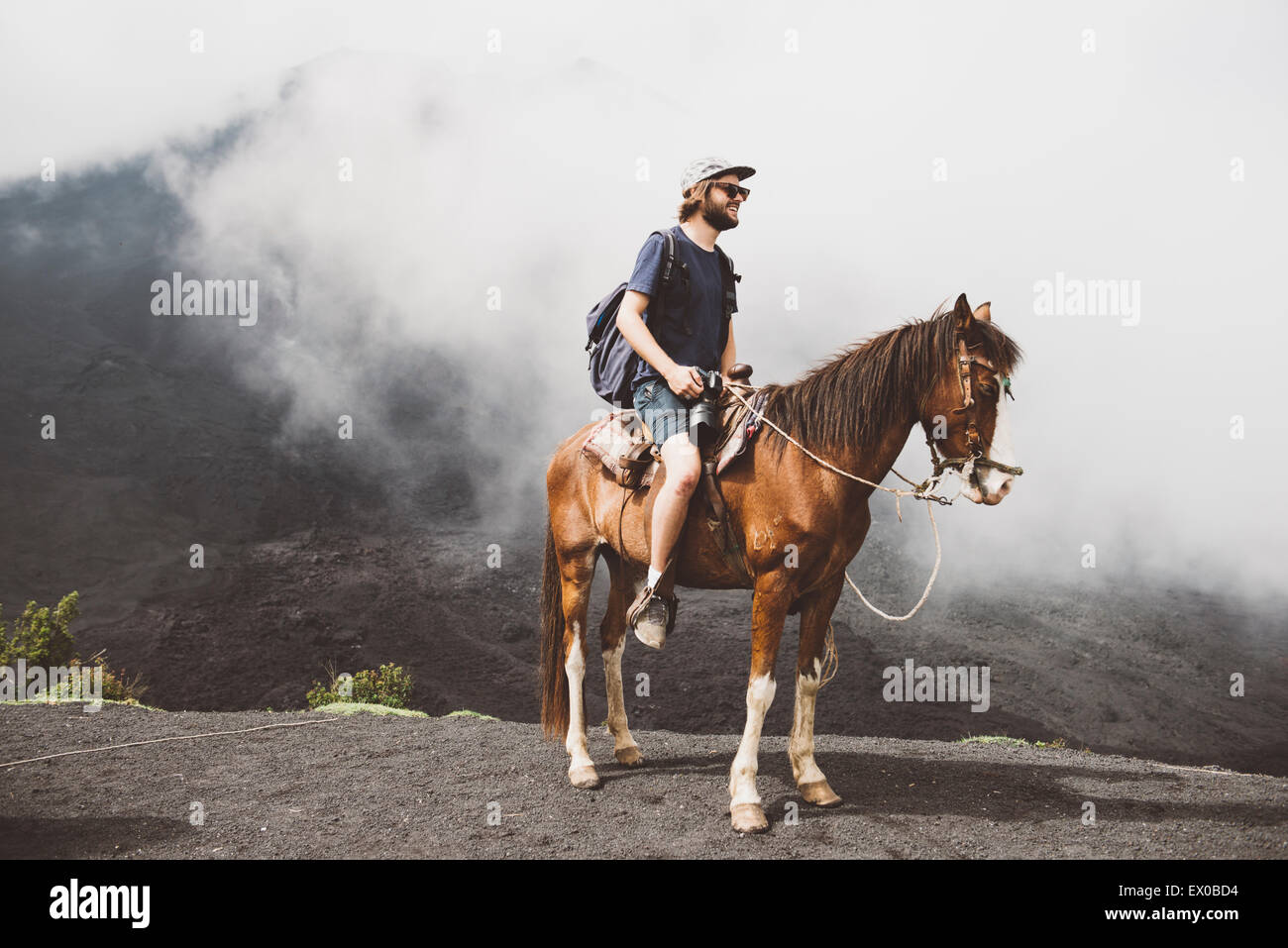 Jeune homme randonnées à cheval au volcan Pacaya, Antigua, Guatemala Banque D'Images