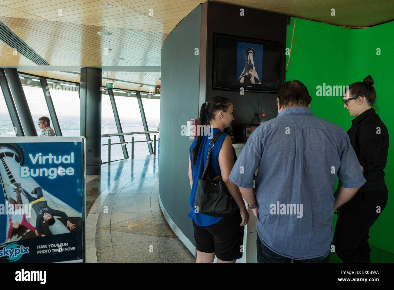 Les vacanciers à un écran vert Photo Booth, où ils peuvent être photoshoped en un saut virtuel de la Skytower à Auckla Banque D'Images