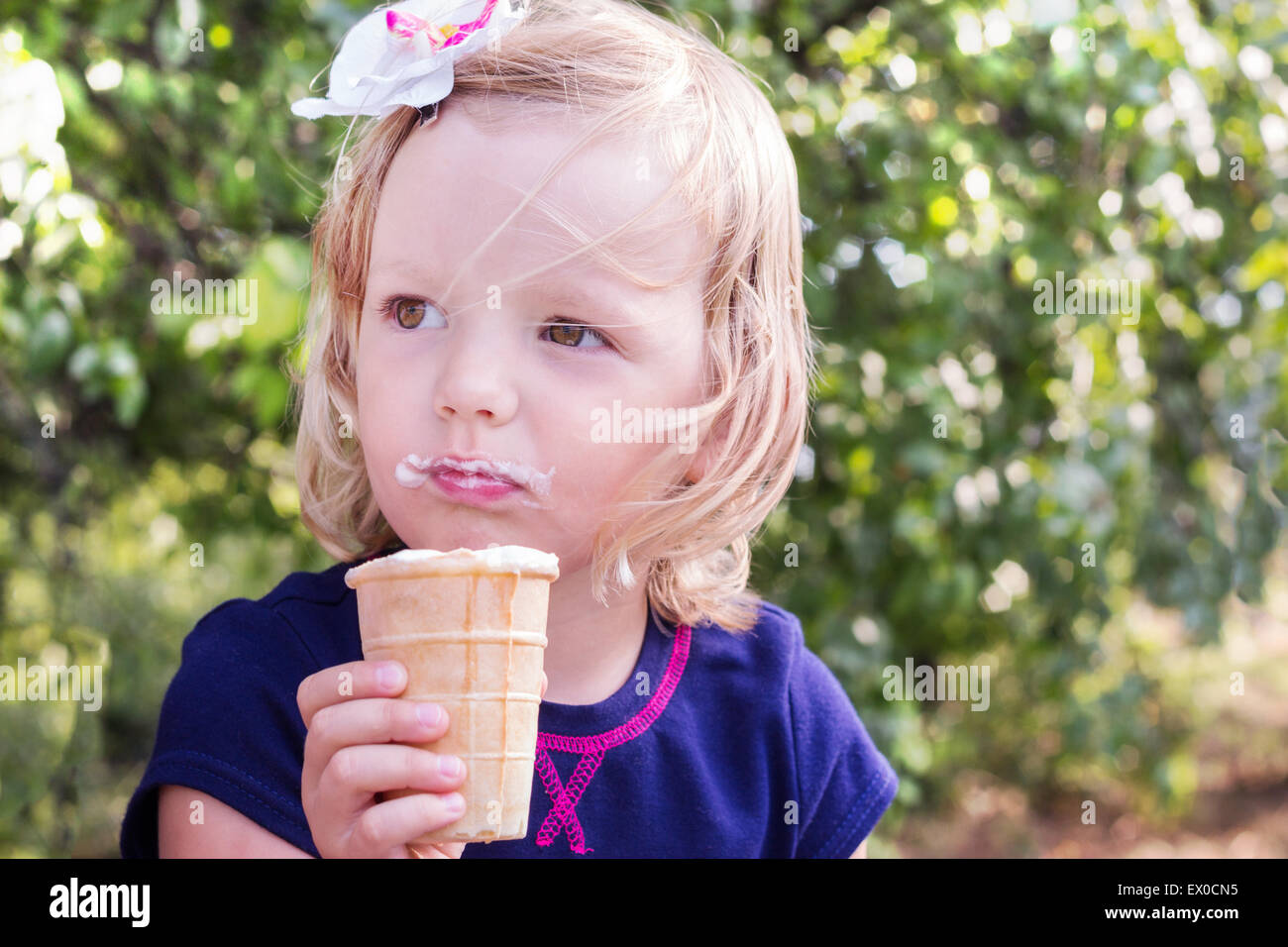 Pretty Little girl eating ice cream dans l'été le parc. Banque D'Images