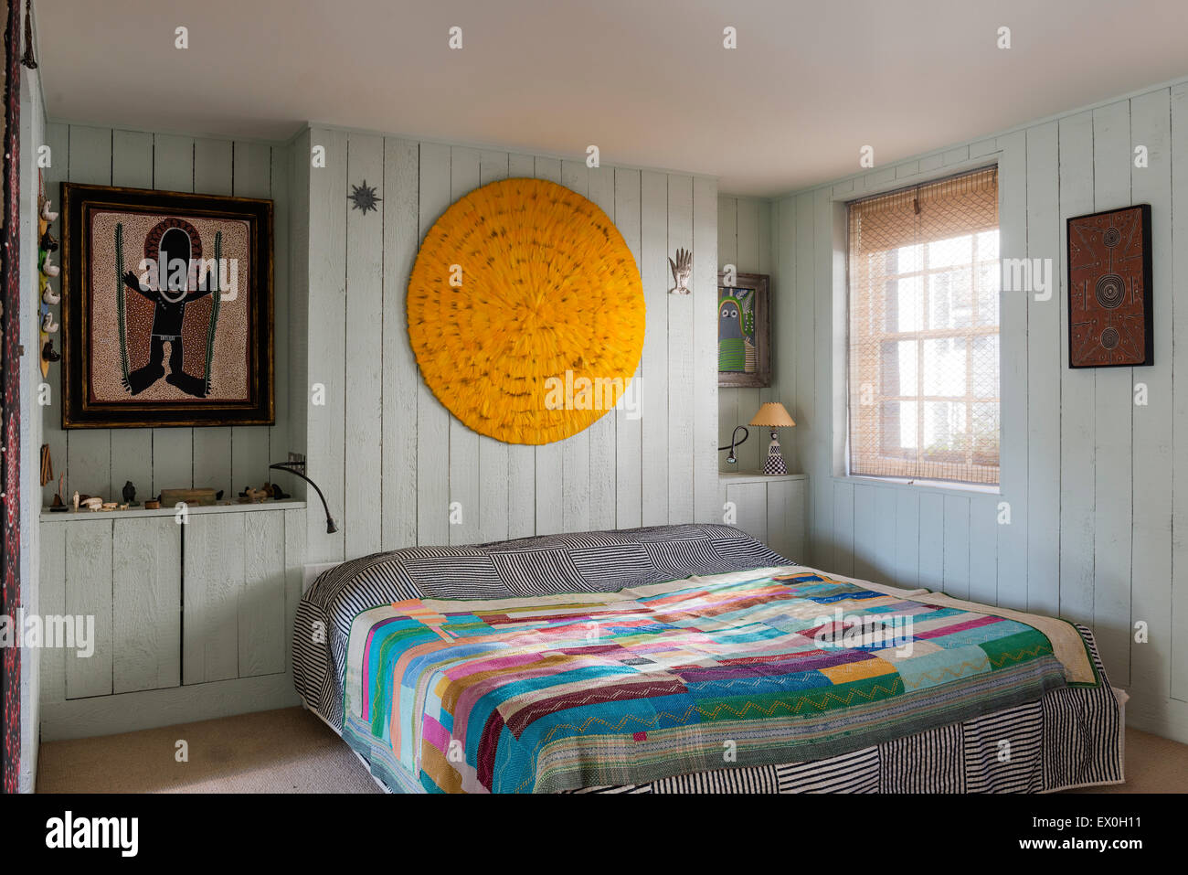 Une plume jaune mandala fait par le designer Simon Costin au-dessus de lit dans la chambre avec la peinture par l'artiste autochtone David Downs. Banque D'Images