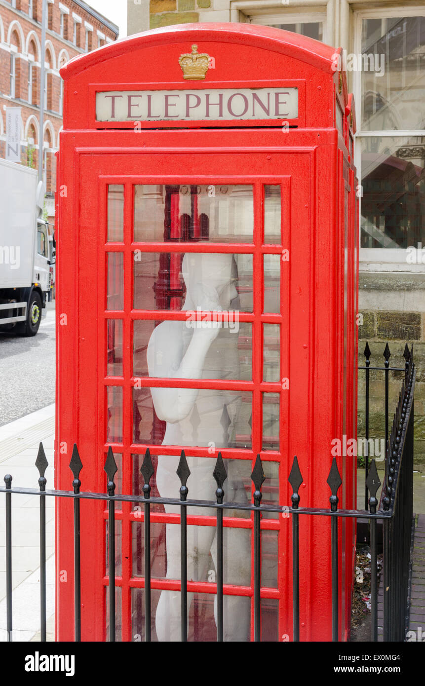 Boîte de téléphone rouge avec fullsize statue d'un homme à l'intérieur de St Giles' Square, Northampton Banque D'Images