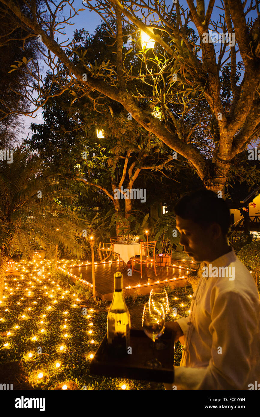 Un dîner spécial 500 Candel avec serveur au crépuscule. La Residence Phou Vao. Luang Prabang, Laos Banque D'Images