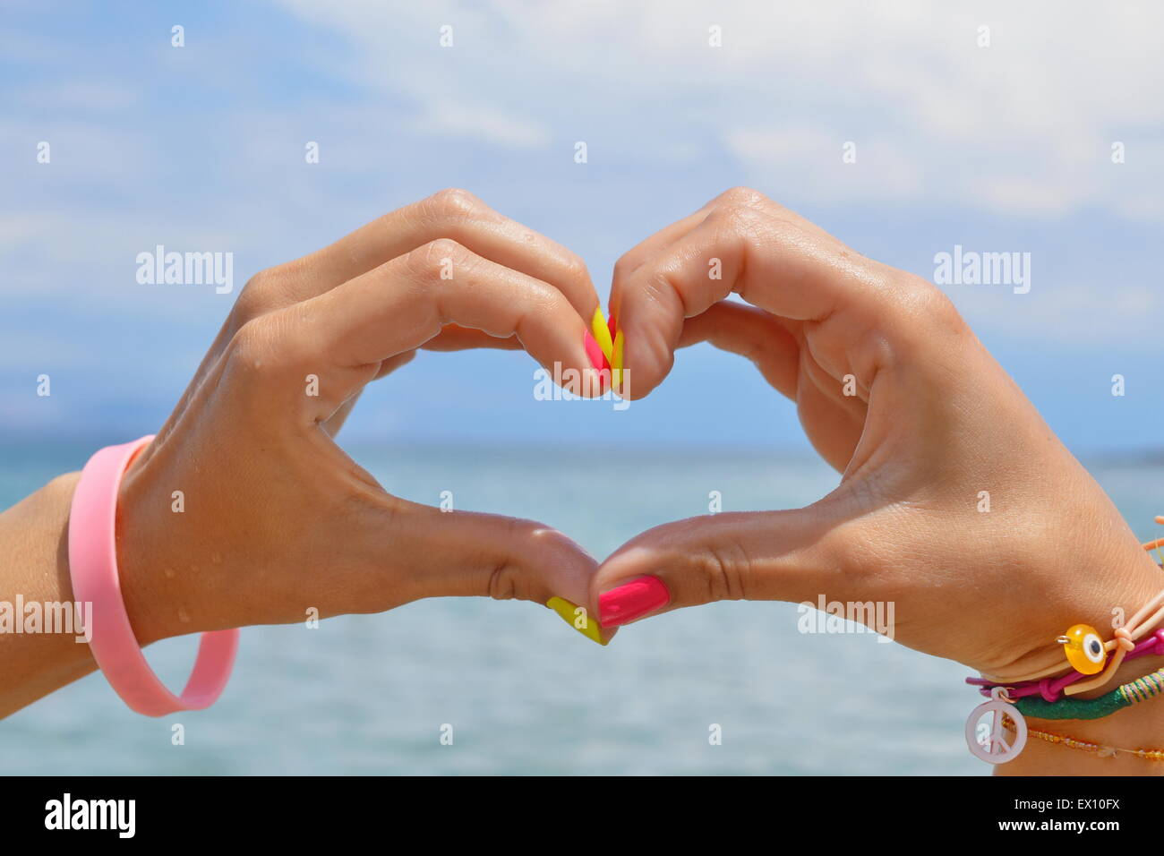 En forme de coeur des mains contre la mer et le ciel à la recherche de l'eau à Banque D'Images