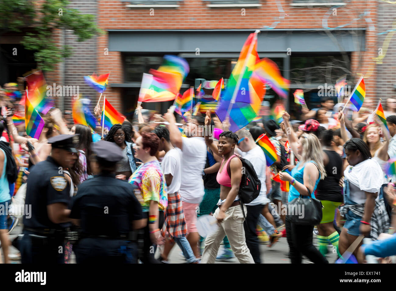 La VILLE DE NEW YORK, USA - 28 juin 2015 : lors de l'Assemblée célébrants gay pride parade des drapeaux arc-en-ciel vague comme ils passent de la police. Banque D'Images