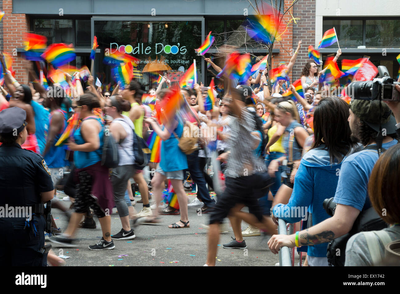 La VILLE DE NEW YORK, USA - 28 juin 2015 : lors de l'Assemblée célébrants gay pride parade des drapeaux arc-en-ciel vague comme ils passent les spectateurs. Banque D'Images