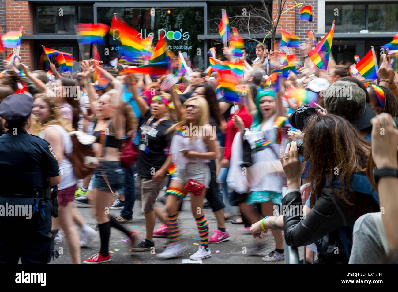 La VILLE DE NEW YORK, USA - 28 juin 2015 : lors de l'Assemblée célébrants gay pride parade des drapeaux arc-en-ciel de l'onde passant acclamer les spectateurs. Banque D'Images