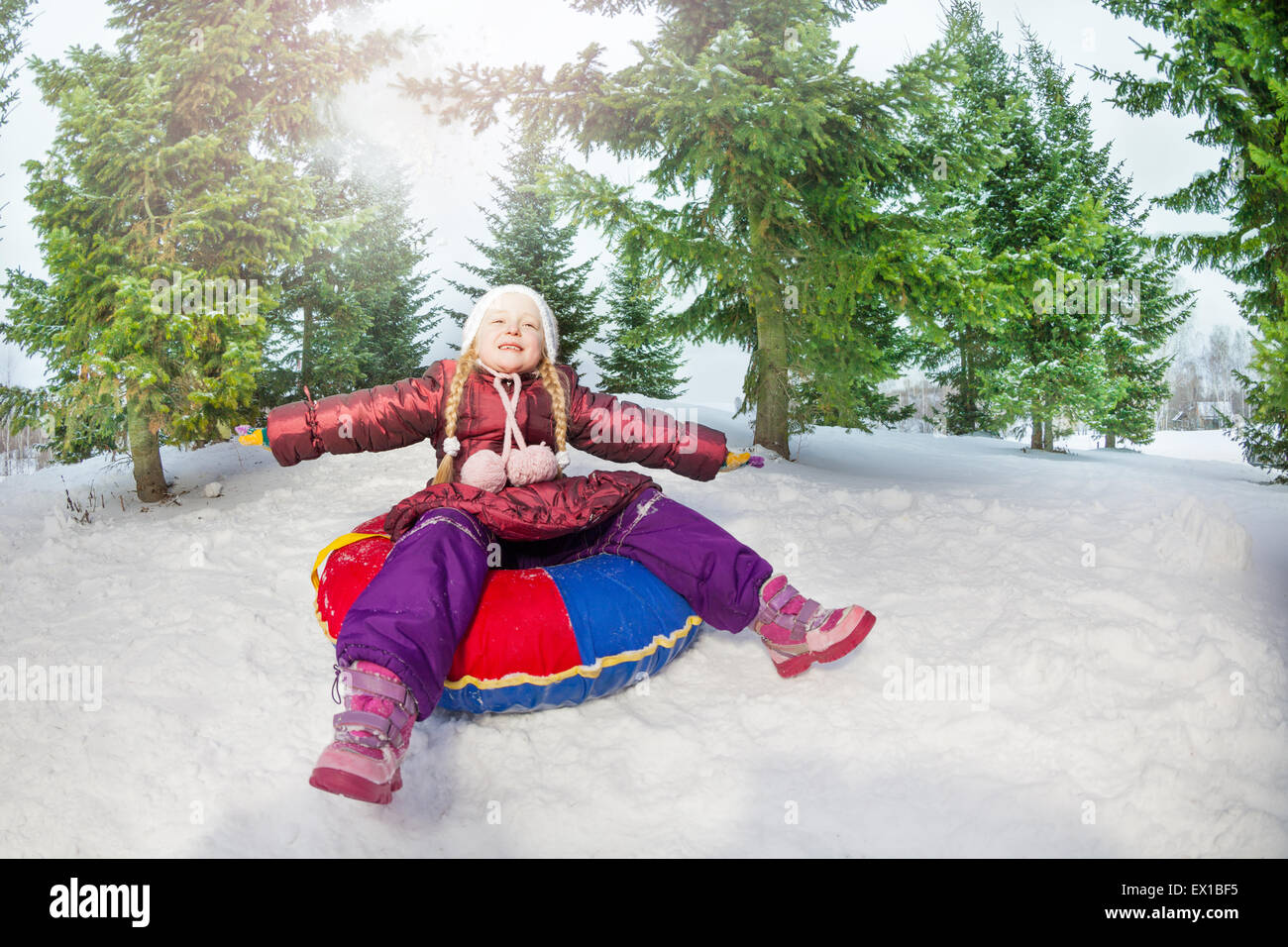Girl sitting on snow tube assoupli en hiver Banque D'Images