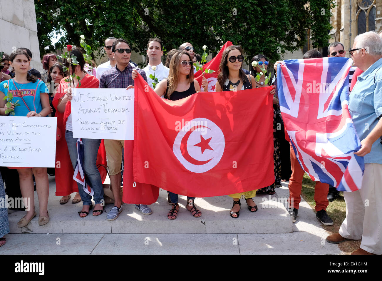 Un titulaire d'un Tunisien et tunisienne britannique drapeaux lors d'un rassemblement contre le terrorisme, London, UK Banque D'Images