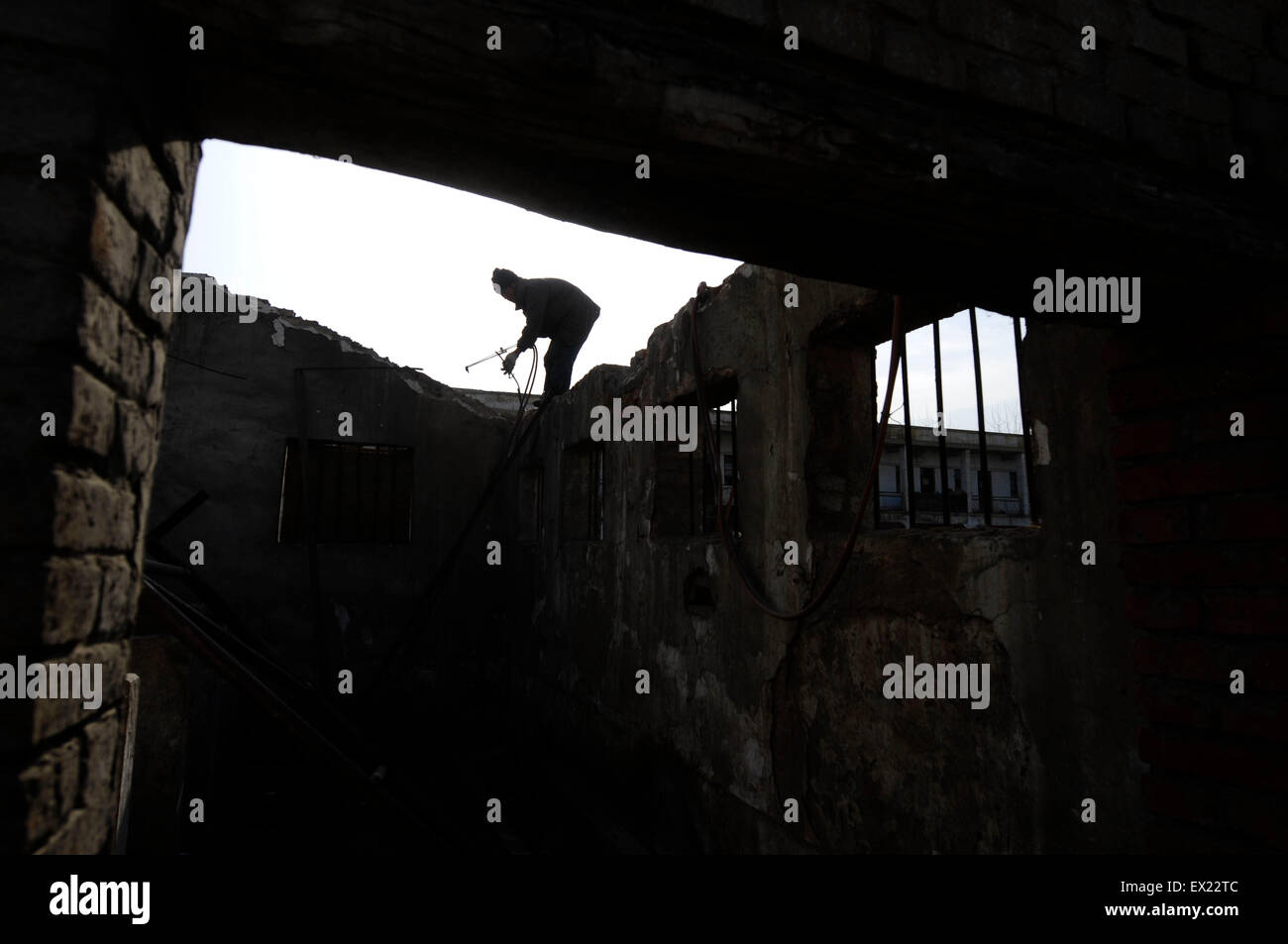 Un manoeuvre backouts un vieux bâtiment à un chantier de démolition à Shenzhen, dans la province du Shanxi, le 29 janvier 2010. VCP Banque D'Images