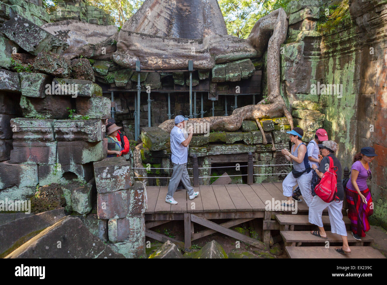 Les touristes à pied sur la passerelle en bois à Ta Prohm temple, Angkor. Banque D'Images