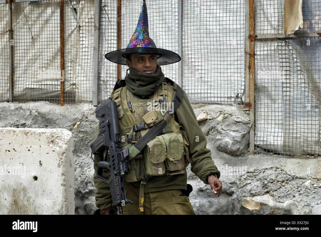 Un soldat israélien armé de la communauté Beta Israël également connu sous le nom de Juifs éthiopiens portant un chapeau de clown lors de fête de Pourim à Tel Rumeida juifs Cisjordanie Israël Banque D'Images