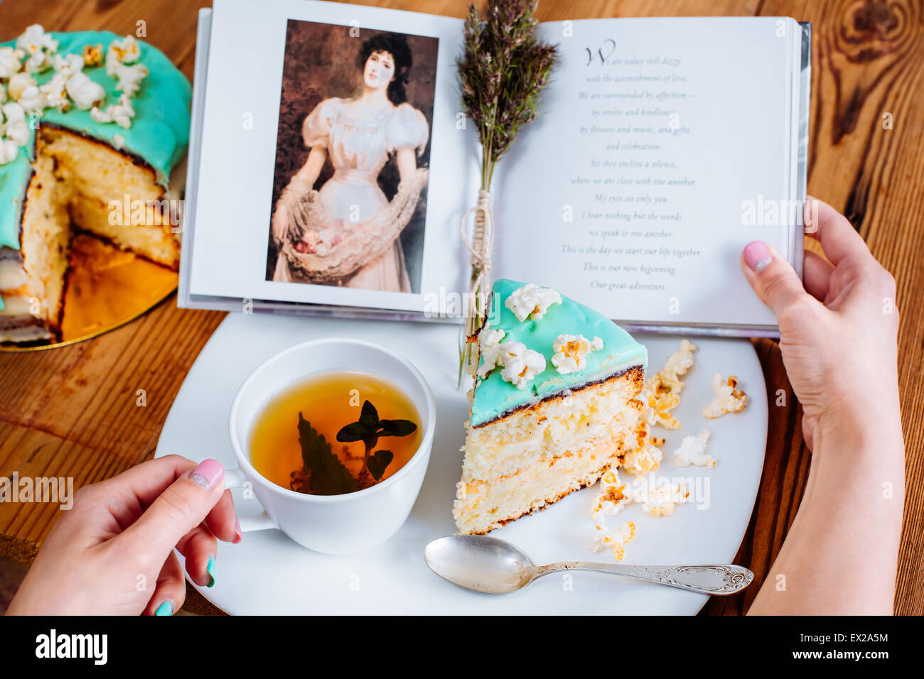 Lisez le livre de gâteaux thé popcorn mains lecture turquoise Banque D'Images