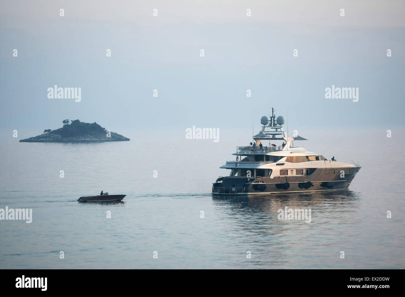 Un yacht et d'une petite embarcation à moteur navigation dans la mer Adriatique à côté d'une petite île au coucher du soleil à Rovinj, Croatie Banque D'Images