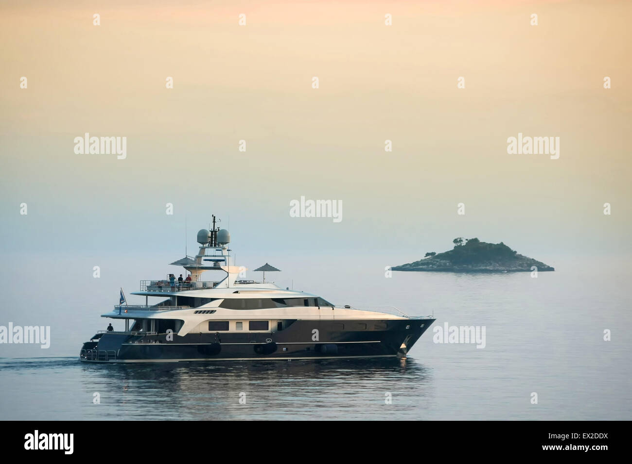 Un yacht voile dans la mer Adriatique à côté d'une petite île au coucher du soleil à Rovinj, Croatie. Banque D'Images