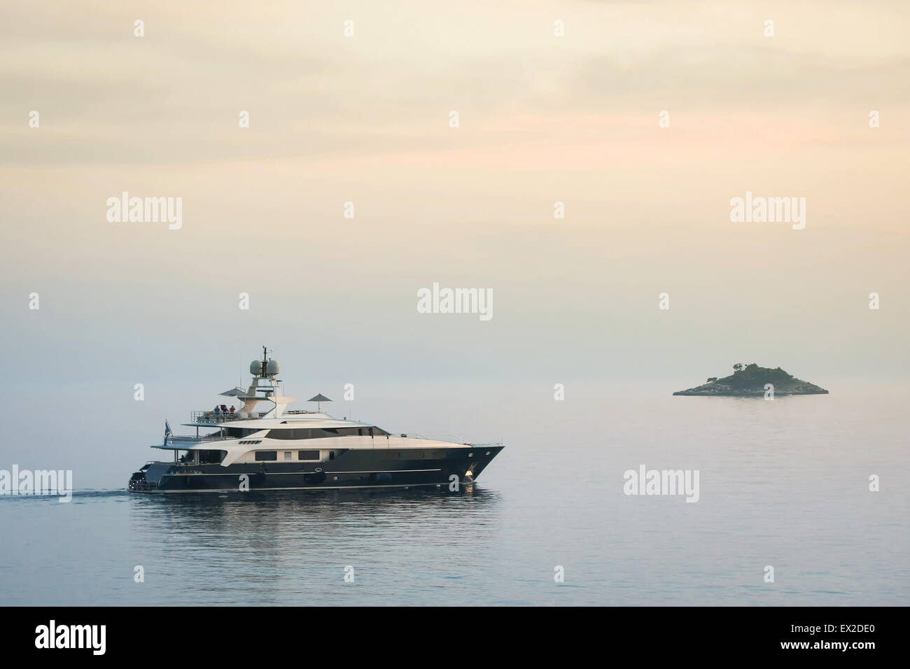 Un yacht voile dans la mer Adriatique à côté d'une petite île au coucher du soleil à Rovinj, Croatie. Banque D'Images