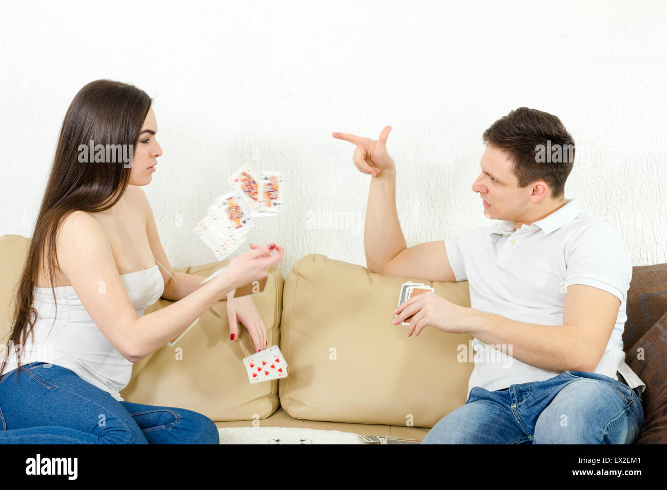 Young adult couple lutte plus stupide jeu de cartes. Points à son petit ami tricher amie et elle jette ses cartes. Coup de colère Banque D'Images