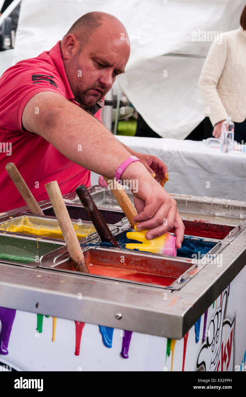 Un homme fait "mains" à l'aide de cire cires multicolores dans un marché Banque D'Images