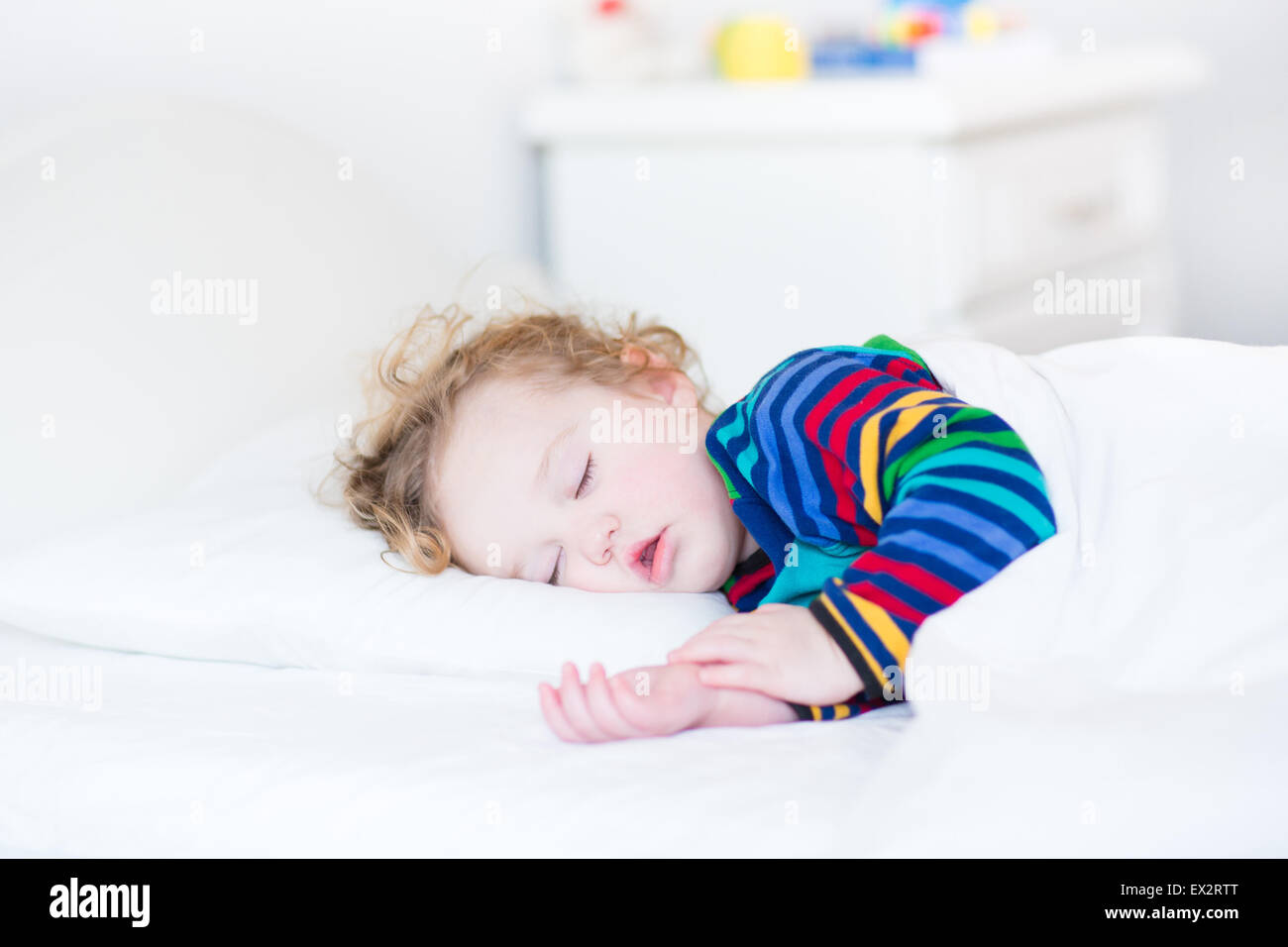 Adorable bébé fille faire la sieste dans une chambre à coucher de soleil blanc Photo Stock Alamy