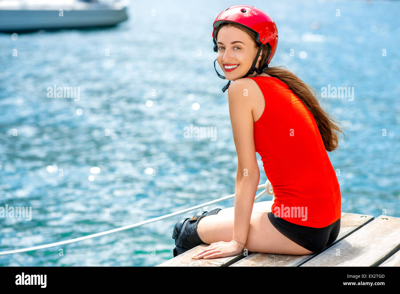 Woman in sportswear avec rouleaux de patinage sur la jetée Banque D'Images