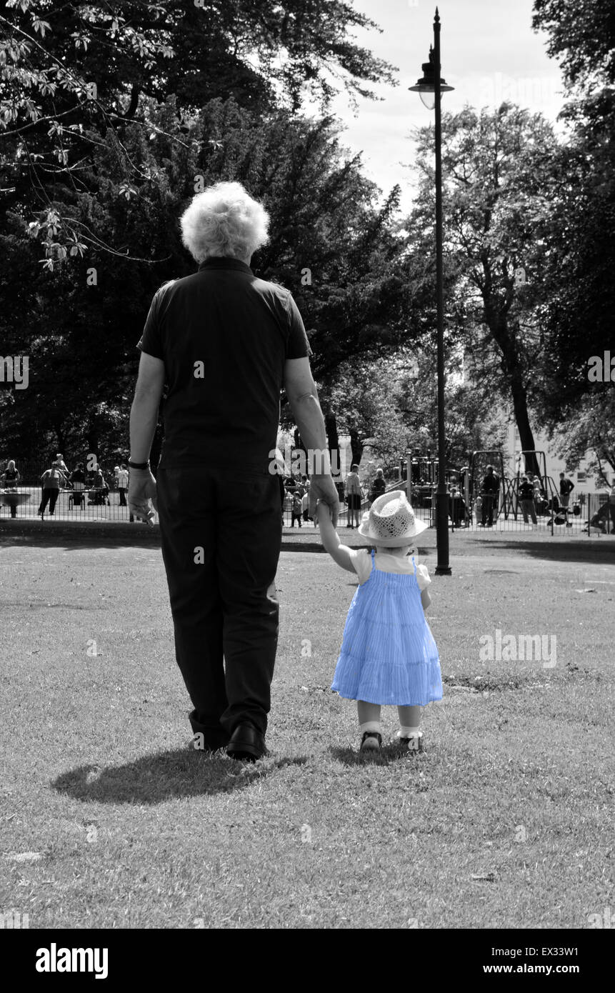 La jeune fille à la robe bleue. Grand-père et petite-fille d'avoir une promenade dans le parc sous le soleil Banque D'Images