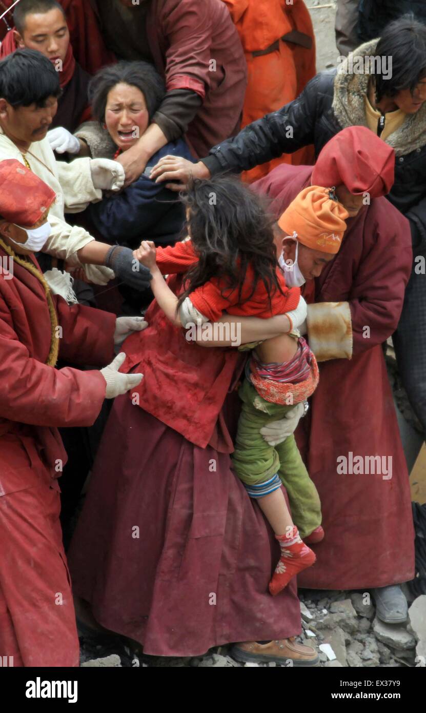 Les sauveteurs déplacer une fillette de 13 ans à partir de débris de maison détruite avec sa mère dans la ville de tremblement de Gyegu à Yushu Banque D'Images