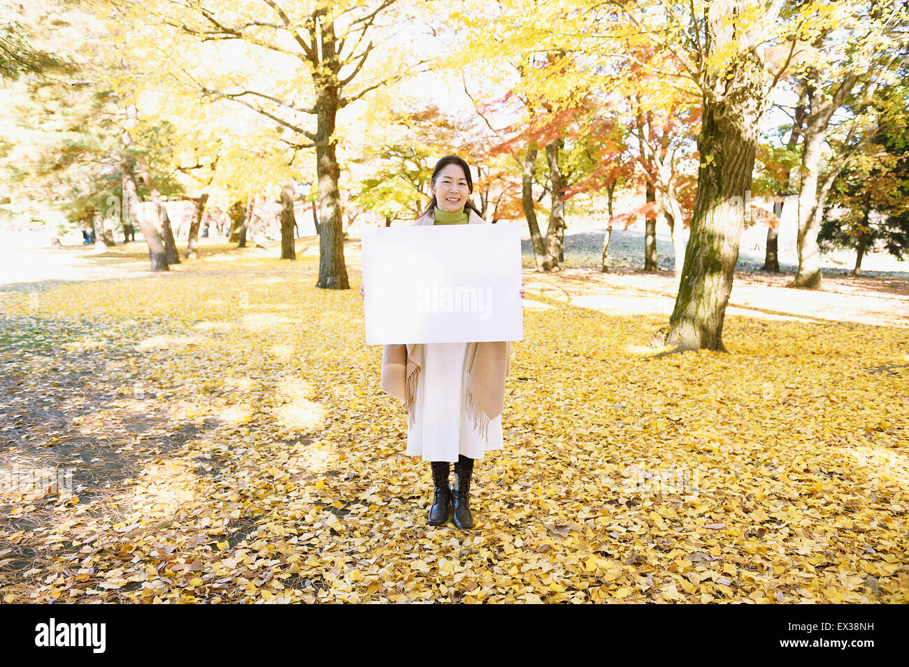 Hauts femme japonaise avec tableau blanc dans un parc de la ville à l'automne Banque D'Images