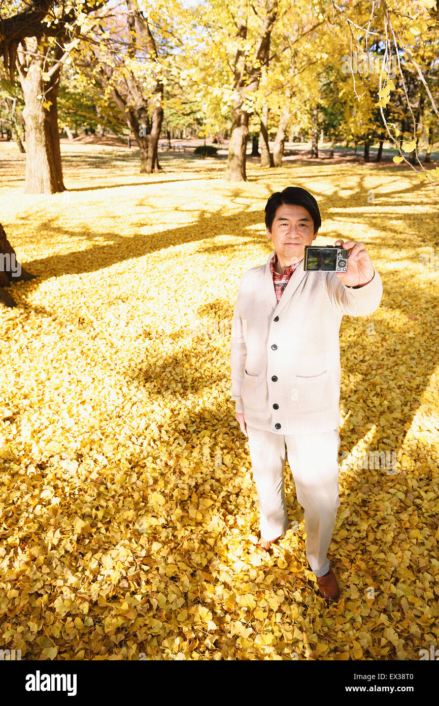 Hauts homme japonais en prenant un dans un parc de la ville selfies en automne Banque D'Images