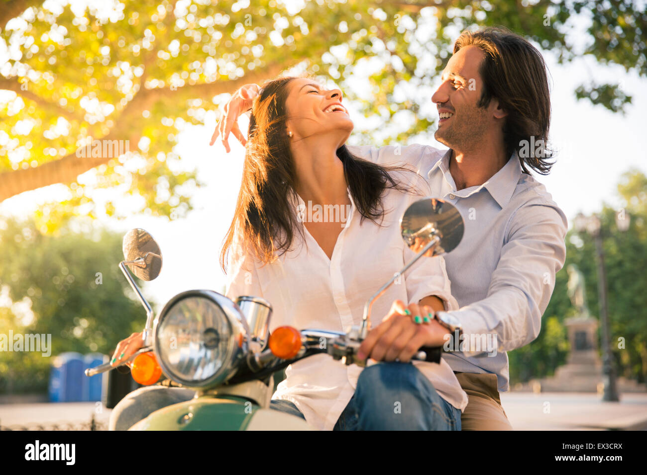 Laughing couple flirting européenne en scooter dans la ville Banque D'Images