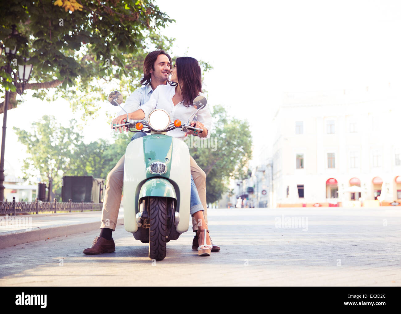L'heureux couple flirting en scooter dans la ville Banque D'Images