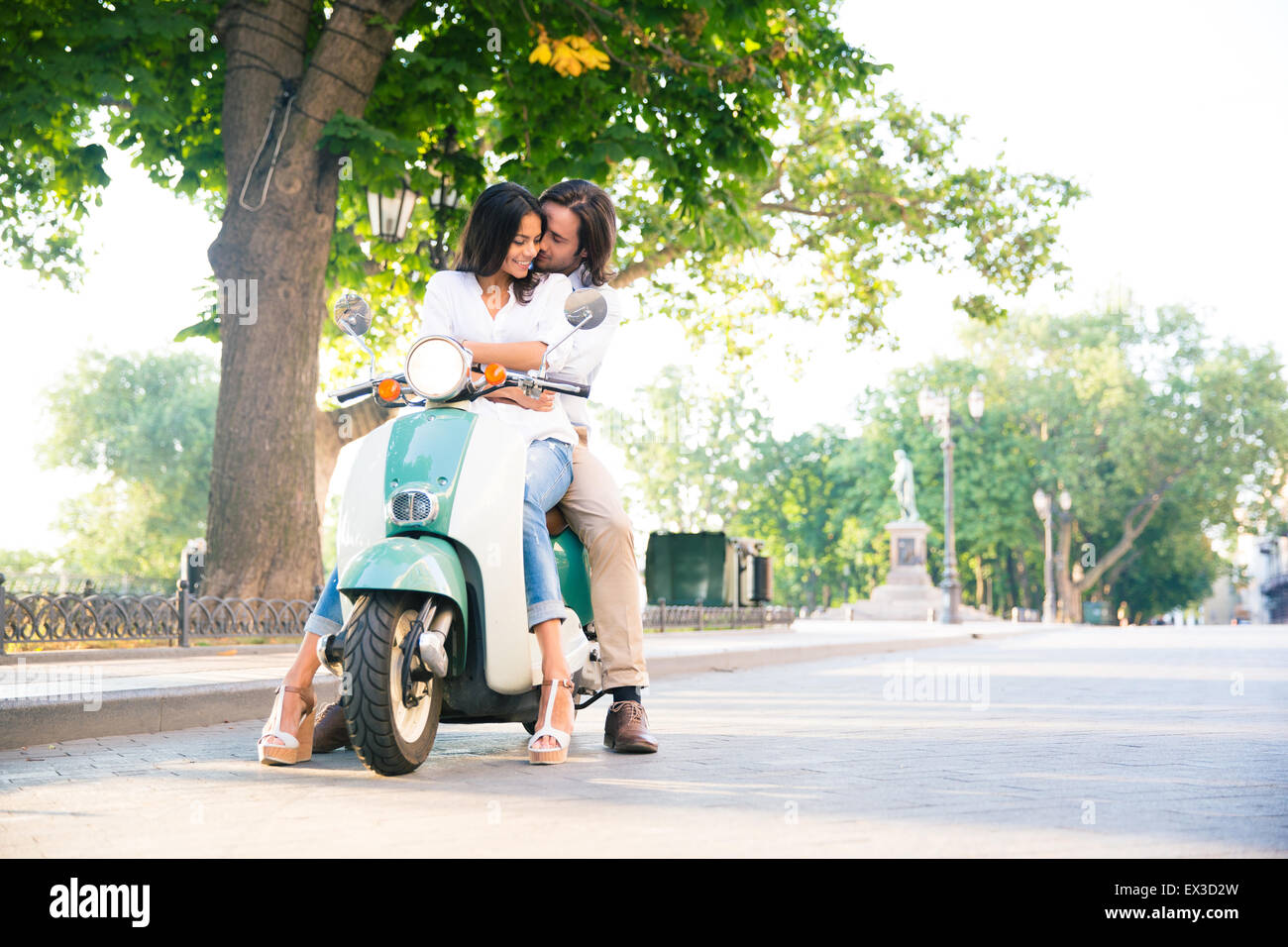 L'heureux couple flirting en scooter dans la ville Banque D'Images