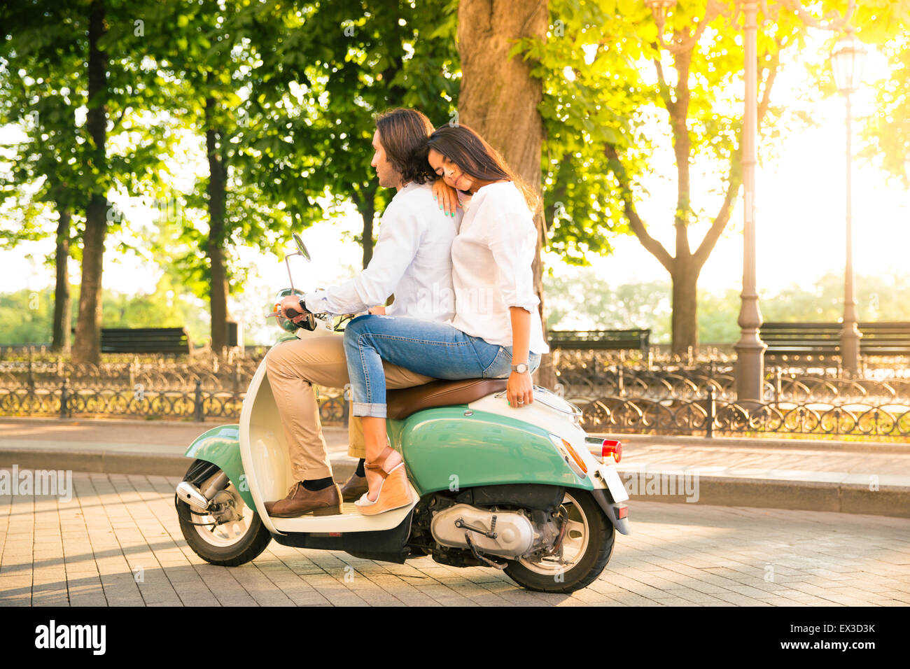 Jeune couple riding a scooter en ville Banque D'Images