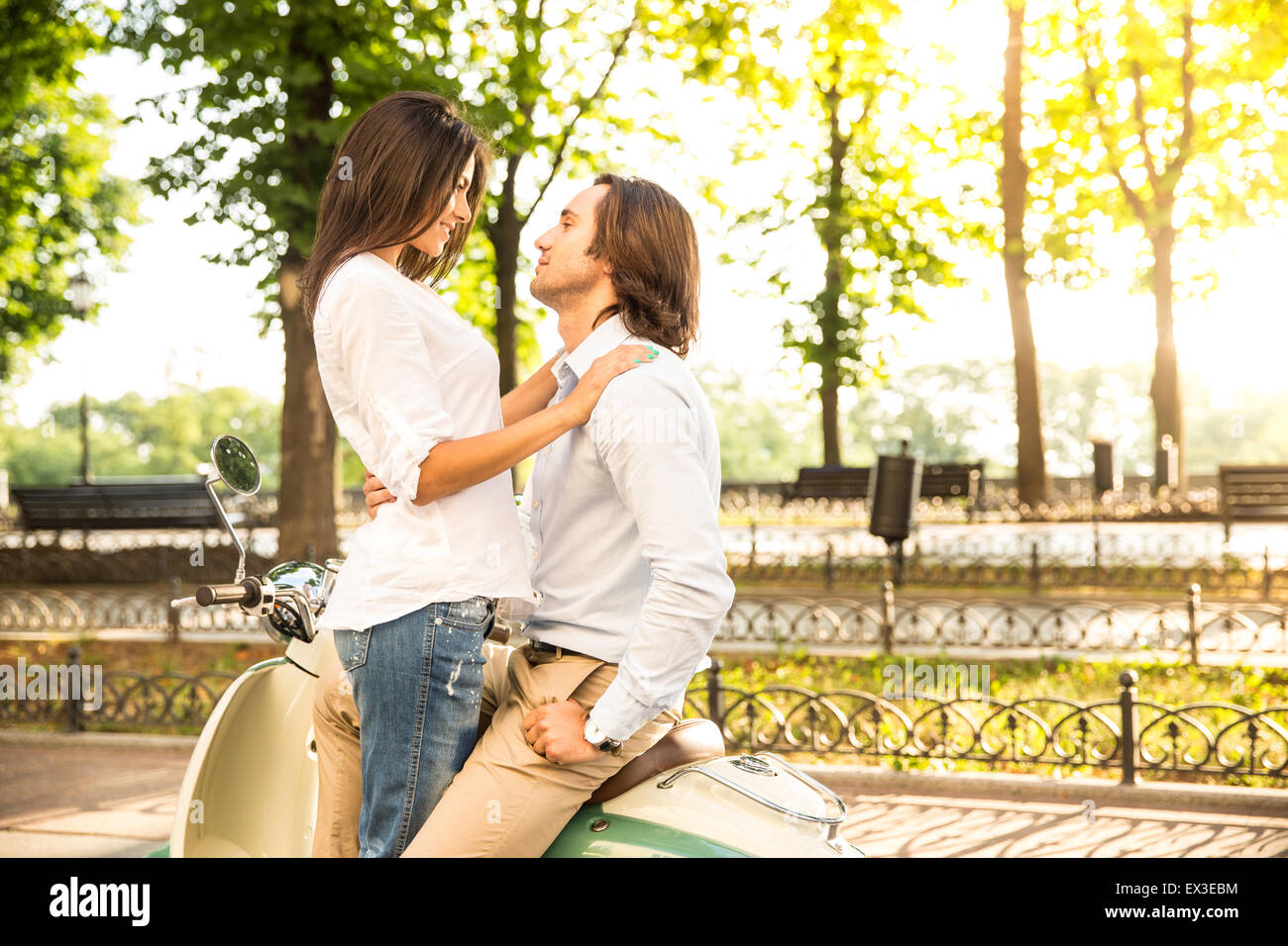 Happy young couple flirting en scooter en plein air Banque D'Images