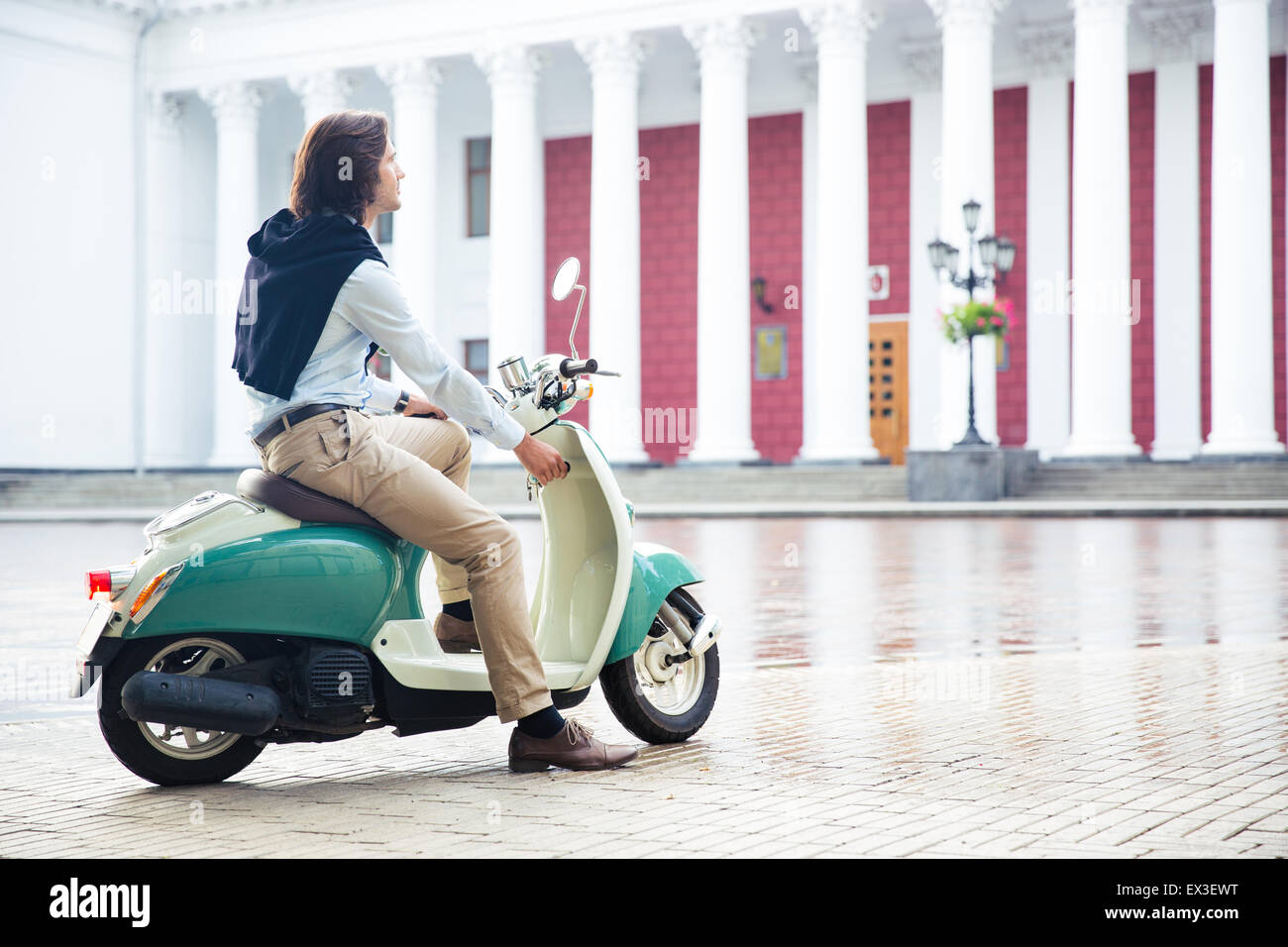 L'homme commence son scooter prêt à conduire la ville Banque D'Images