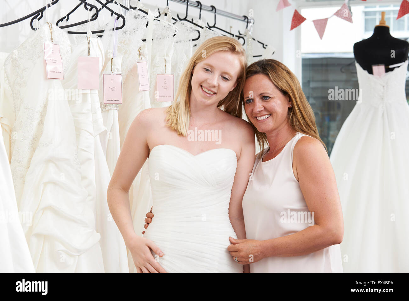 Mère Fille aidant à choisir en magasin nuptiale robe Banque D'Images