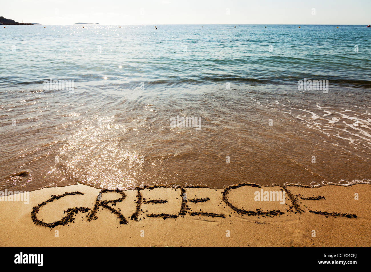 Côte littoral grec Grèce métaphore de couler dans la noyade de la dette sous l'eau mot écrit en sable mer mer Banque D'Images