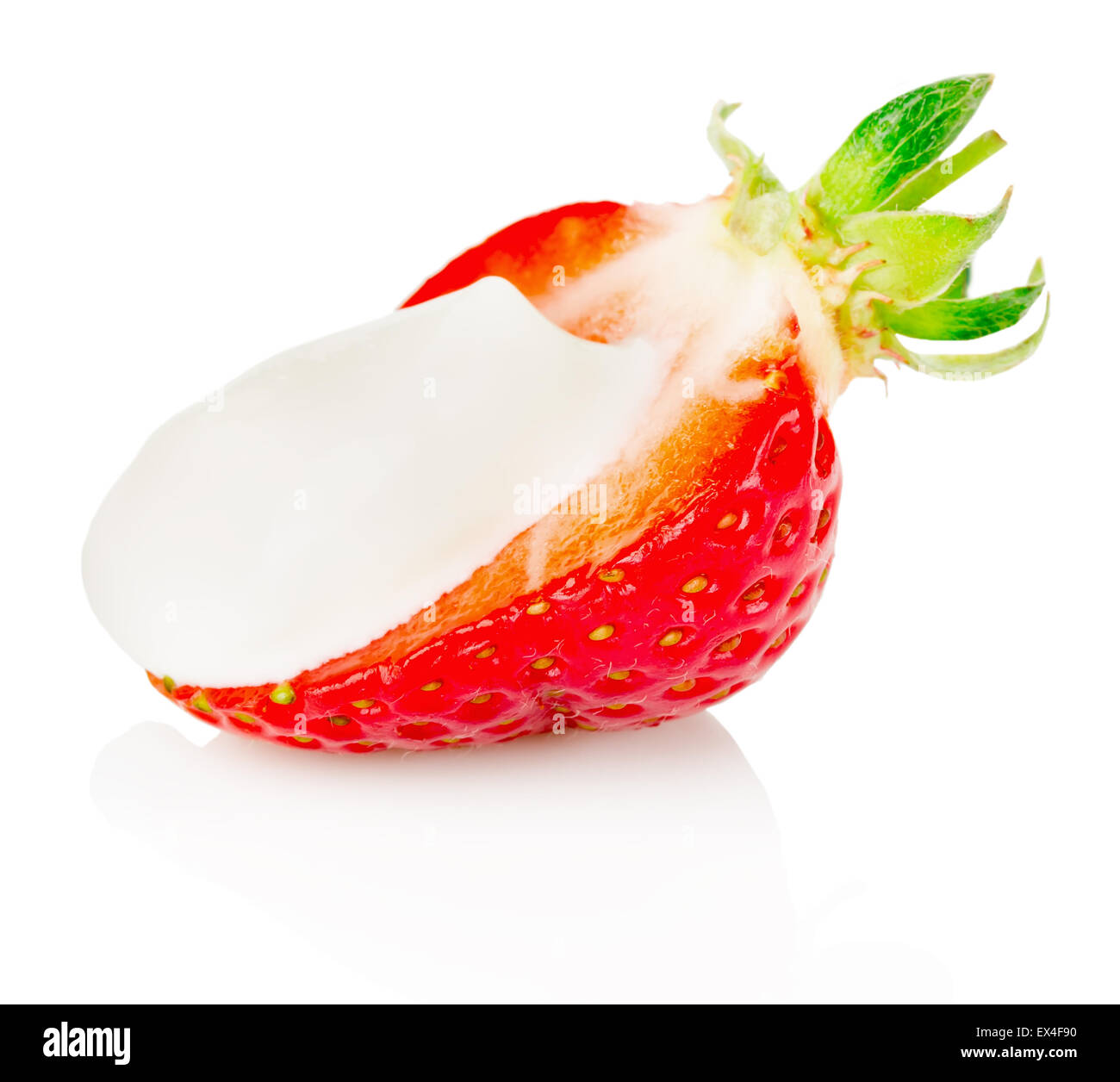 La moitié des fraises avec de la crème sur le fond blanc. Banque D'Images