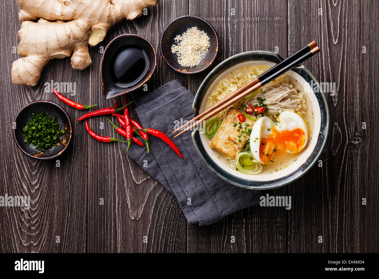 Nouilles ramen Miso asiatique avec des œufs, tofu et enokis dans un bol sur fond de bois gris Banque D'Images