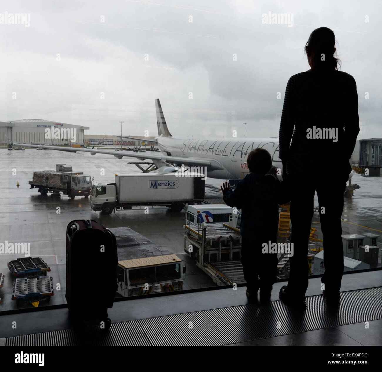 Un jeune garçon et sa maman à la recherche d'une fenêtre de l'aéroport à l'avion Banque D'Images