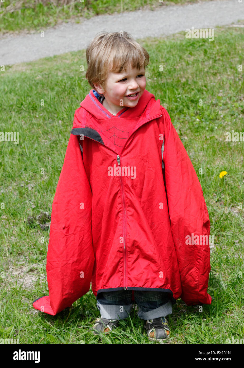 Un petit garçon envahi par un adulte coat Banque D'Images