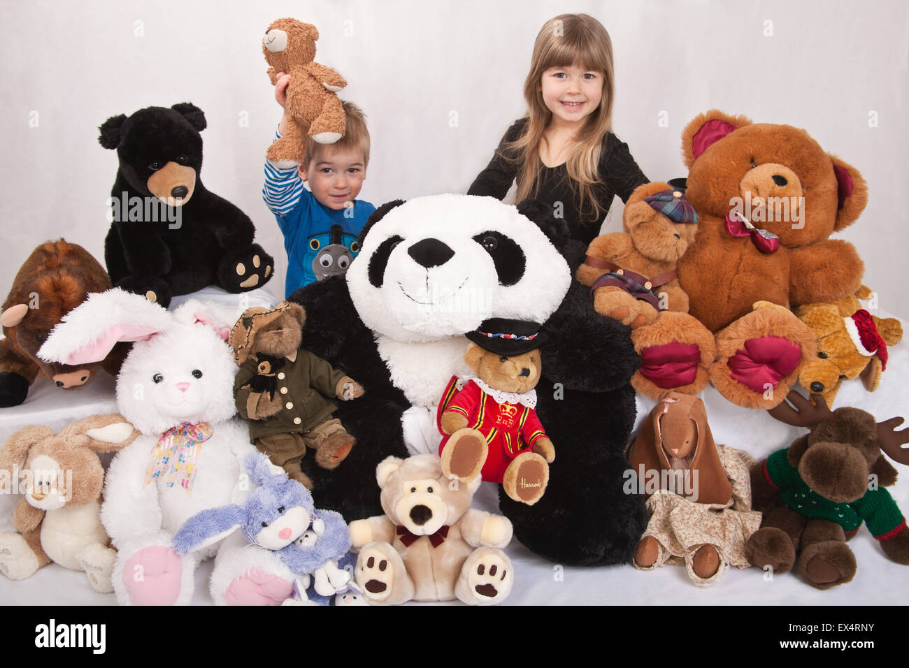 Collection d'animaux naturalisés avec 2 ans boy holding up son ours en peluche, et sa sœur de 5 ans Banque D'Images